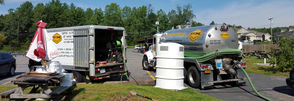 Stone pumper and jetter trucks working on a commercial septic system