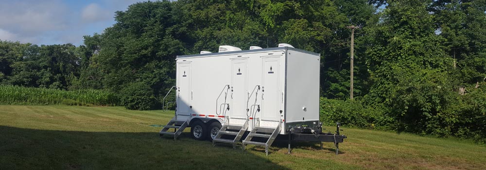 Stone 3-station shower/restroom combo trailer in a field