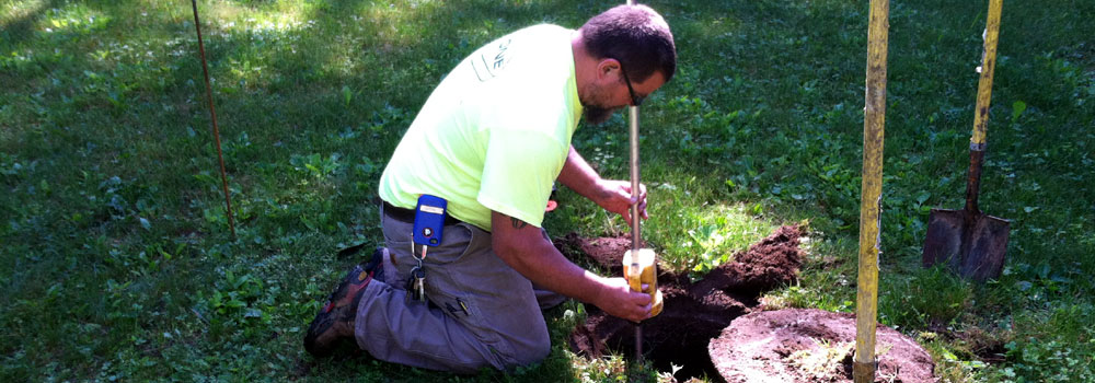 A Stone Industries technician inspects the outlet baffle on a septic tank.