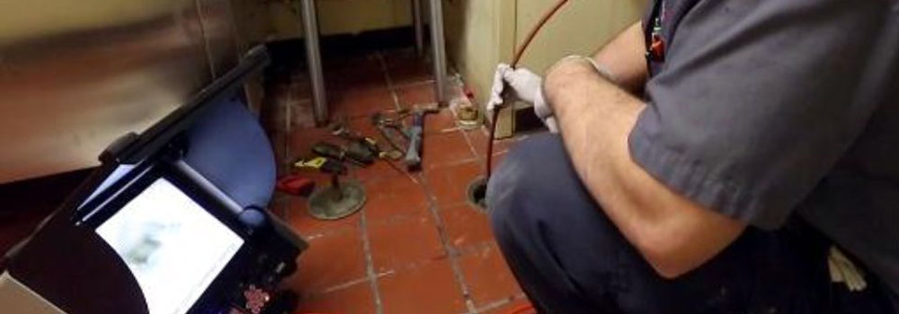 Technician running a video line inspection inside a floor drain