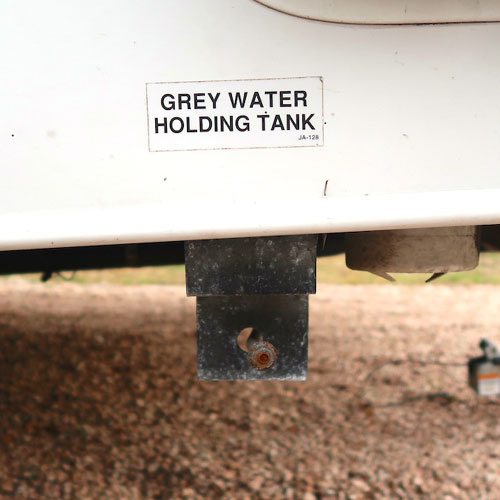 Side of RV with gray water holding tank sticker